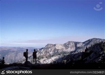 Two Hikers Looking Out Over Mountainous Peaks