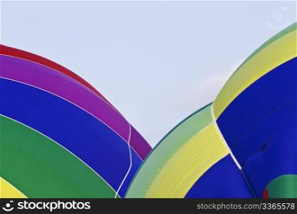Two hot air balloons inflating in early morning with colorful panels creating spherical patterns with copy space in sky center; New Jersey Festival of Ballooning;