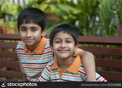 Two Indian brothers sitting happily at a local park