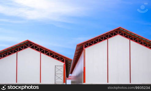 Two industrial cold storage warehouse buildings structure with white sandwich panel wall and red metal gable roof against blue sky in factory construction site area, front view with copy space