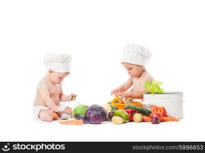 Two infant kids play with vegatables. Babies in chef hats isolated on white. Little chefs cook