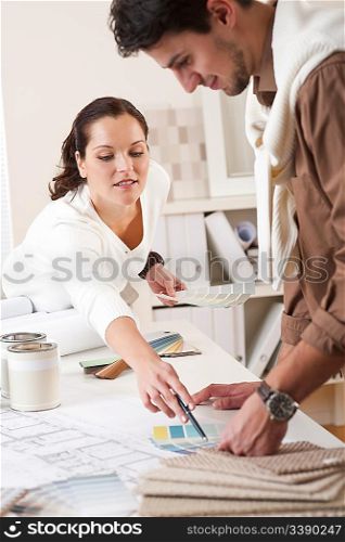 Two interior designer working at office with color swatch and can of paint