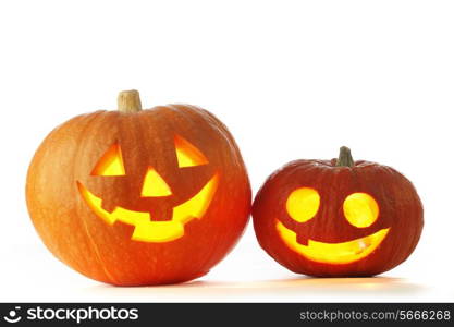 Two Jack O Lantern halloween pumpkins with candle light inside isolated on white background