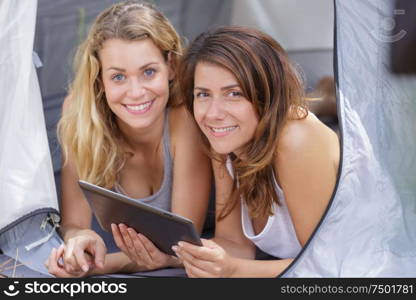 two joyful travelers waking up in a tent