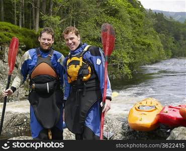 Two Kayakers Standing at Riverbank