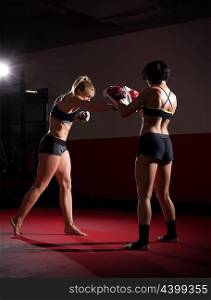 Two kickboxers women in sports hall