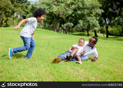 Two kids chasing and playing together while dad caught a boy in park. Two kids chasing and playing together while dad caught a boy in park.