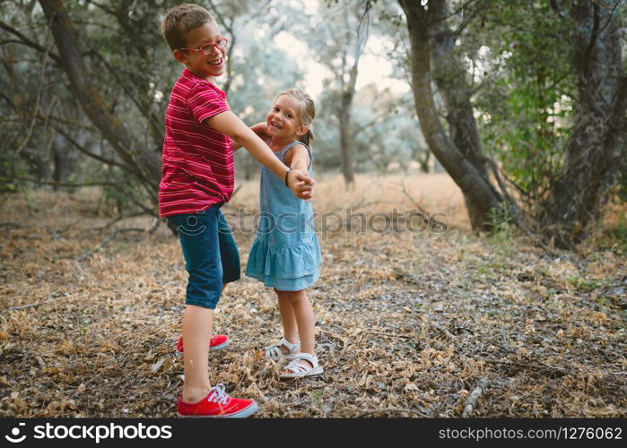 Two kids playing and dancing in the forest