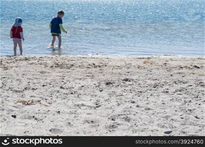 Two kids playing on the beach. Two kids playing on the beach in shallow water