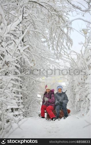 Two kids sliding with sledding in the snow
