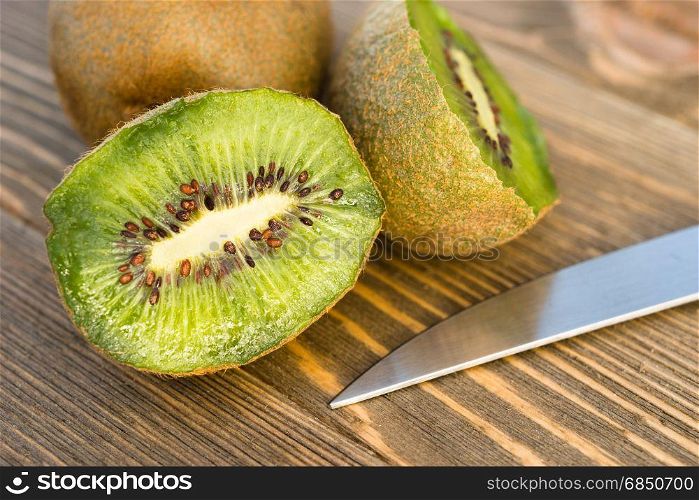 Two Kiwi Fruits sit on the cutting board