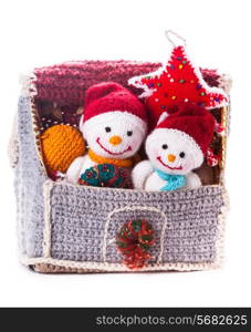 Two knitted christmas snowmen in a house and handmade christmas tree