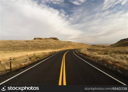 Two Lane blacktop road leads through scenic Oregon State
