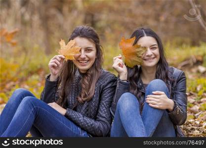 Two laughing girl outdoors in autumn park