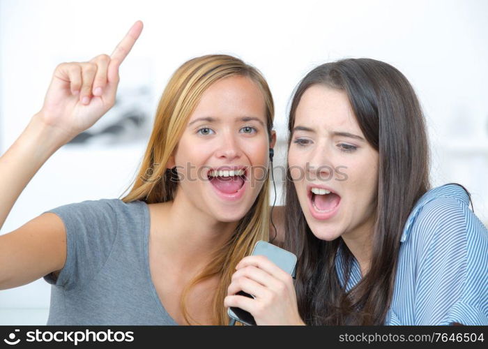 two laughing teenagers are singing