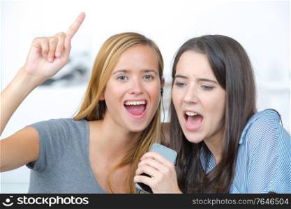two laughing teenagers are singing
