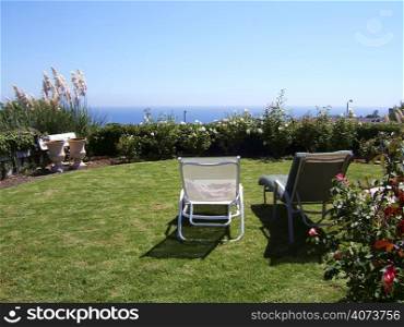 Two lawnchairs overlooking the ocean