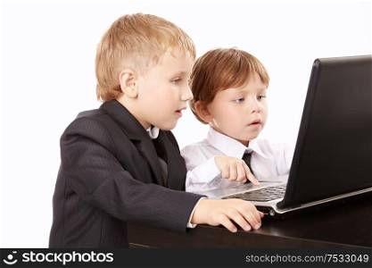 Two little boys in business suits together look in the screen of the laptop, isolated