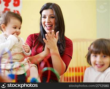 two little girls and female teacher in kindergarten