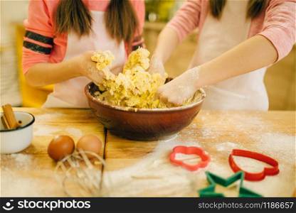 Two little girls chefs crumple the dough, cookies preparation on the kitchen. Kids cooking pastry, children cooks preparing cake