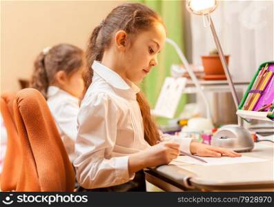 Two little girls drawing pictures