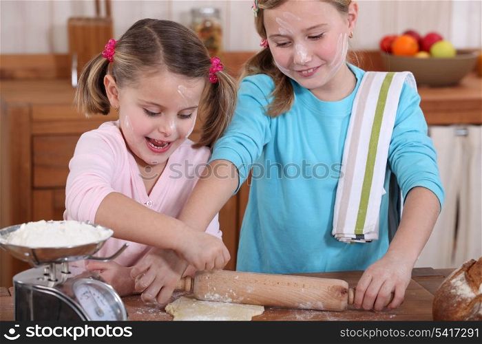 two little girls making pancakes