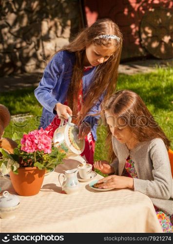 Two little girls playing in teatime at yard