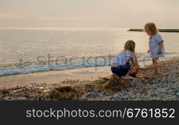 Two little girls playing on the sunset beach