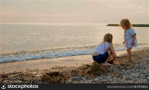 Two little girls playing on the sunset beach