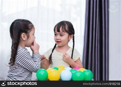 Two little girls playing small toy balls in home together. Education and Happiness lifestyle concept. Funny learning and Children development theme. Smile faces