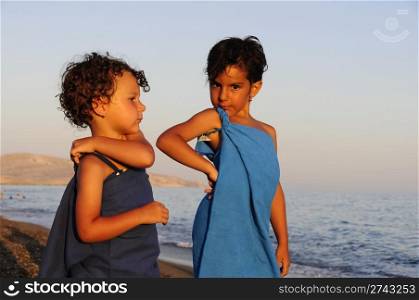 two little girls posing dressed up in towels at seaside