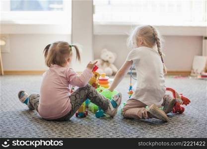 two little girls sitting floor playing