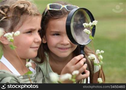 Two little girls with magnifying glasses