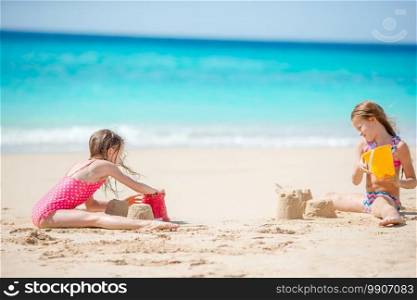 Two little kids making sand castle and playing at tropical beach. Two kids making sand castle and having fun at tropical beach