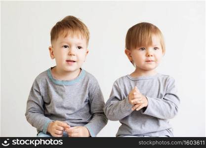 Two little kids. Portrait of a happy little children - boy and girl. Beautiful kids against a white background