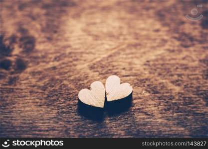 Two little light hearts on a wooden background. Love symbol. Valentine"s Day.. Two hearts on a wooden background