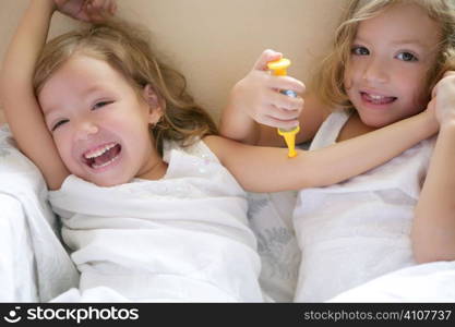 Two little twin sisters playing to be doctors with syringe