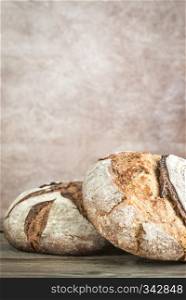 Two loaves of bread on the old-fashioned background