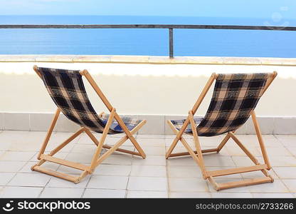 two longes on veranda on sea