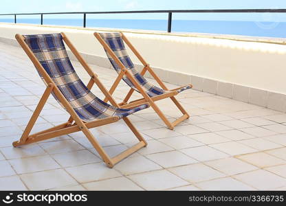 two longes on veranda on sea