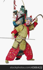 Two male Chinese opera performers gesturing with weapons