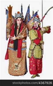 Two male Chinese opera performers gesturing with weapons