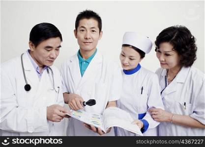 Two male doctors and a female nurse looking at a report