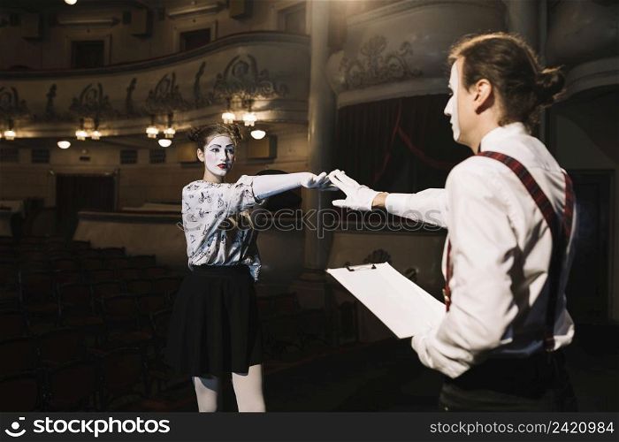 two male female mime artist rehearsing stage auditorium