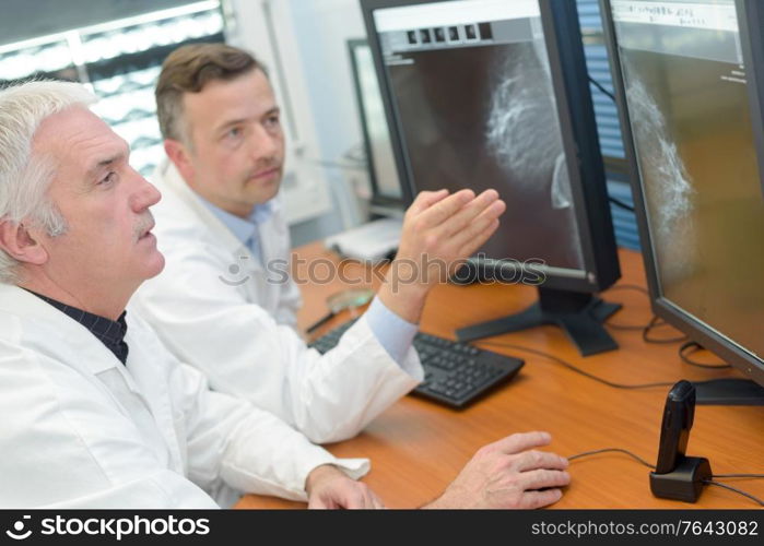 two male medical staff consulting computer screens