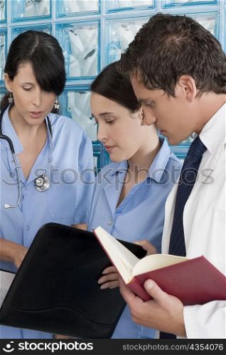 Two male surgeons and a male doctor discussing a medical report