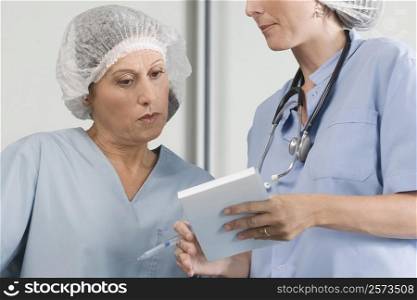 Two male surgeons discussing a medical report