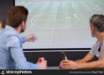 two man in bar watching football drinking beer