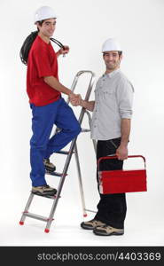 Two manual workers greeting each other