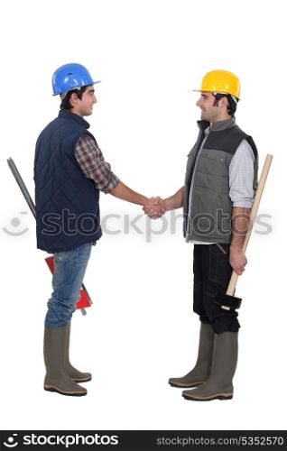 Two manual workers greeting each other